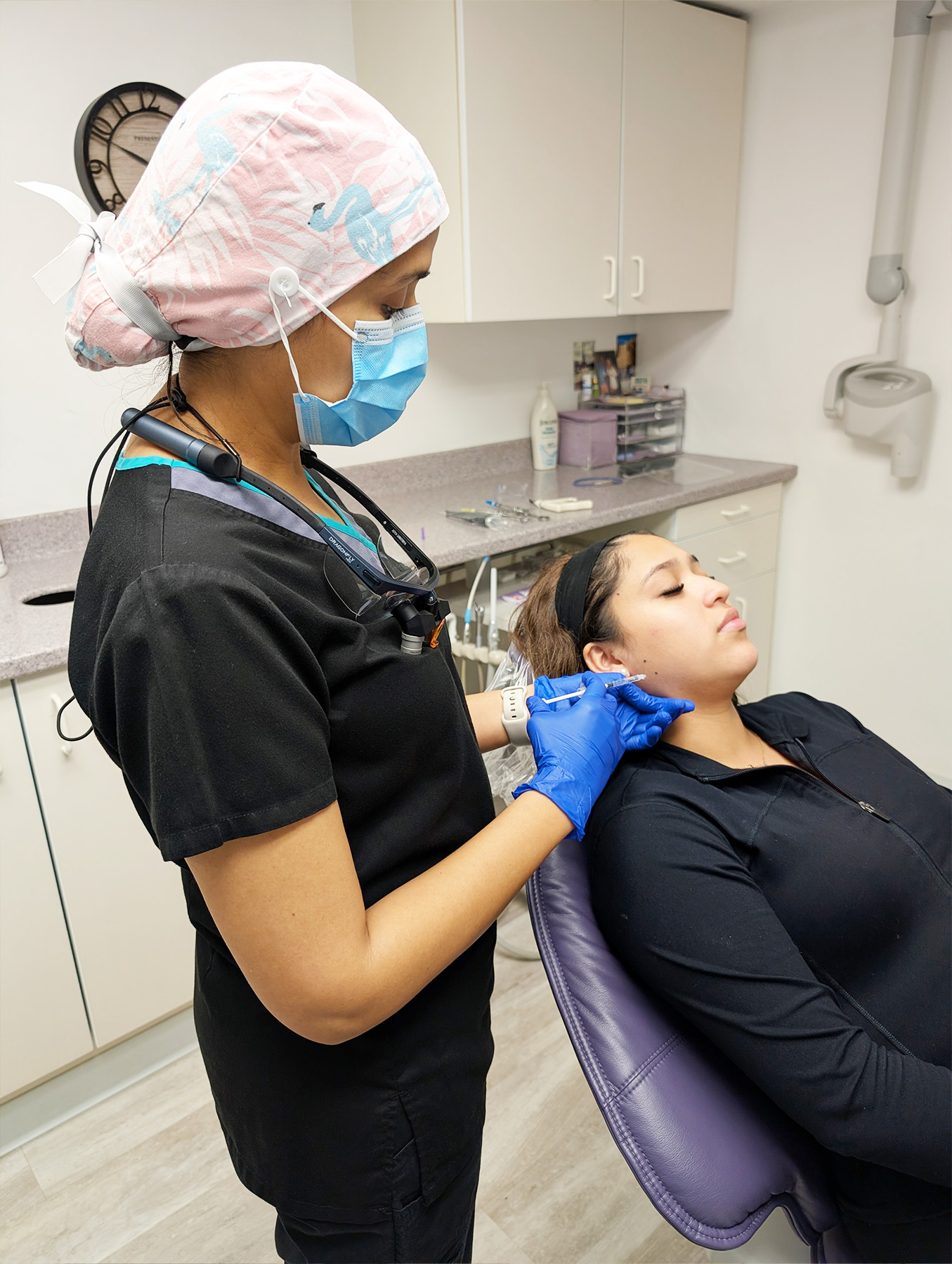 A dental hygienist working on a patient s teeth at a dental office.