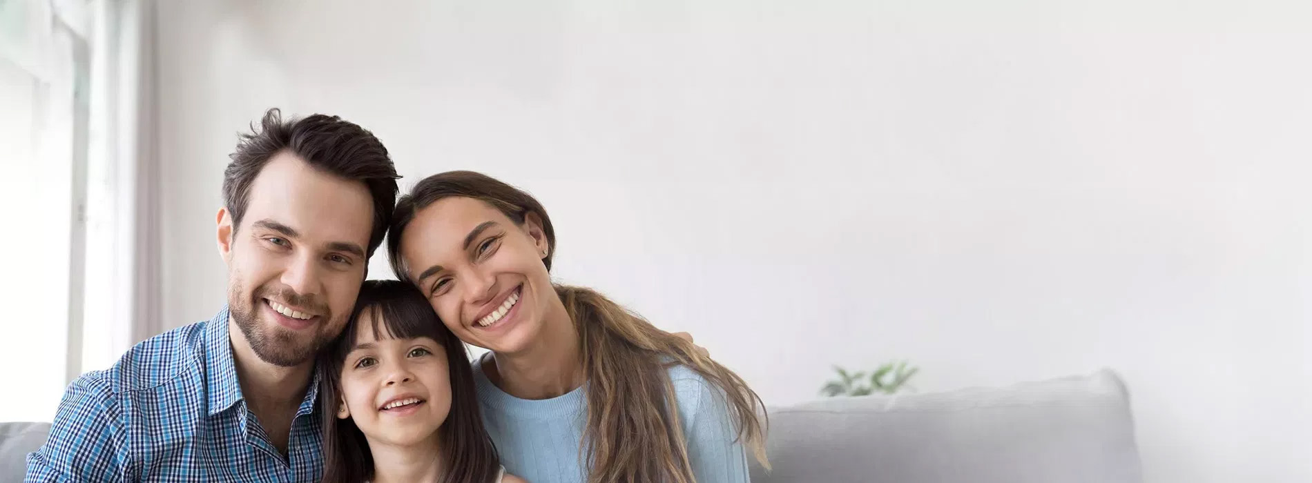 A family of four poses together in a warm indoor setting.