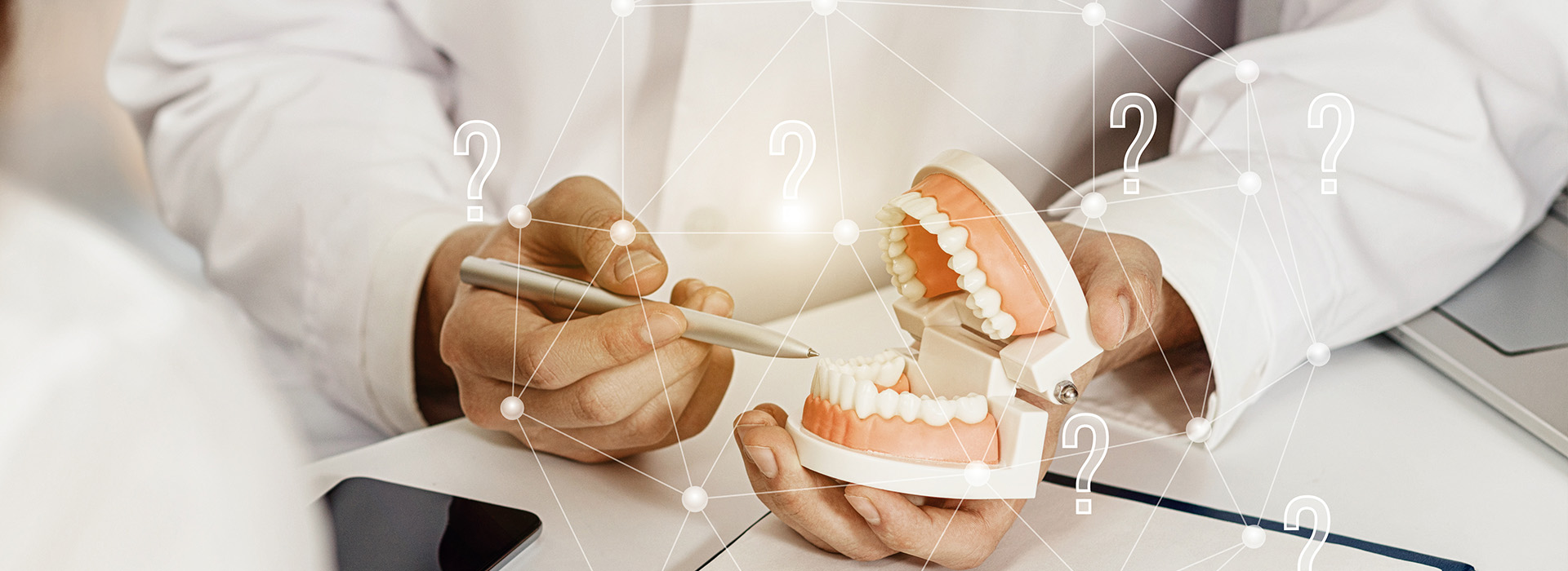 An individual with a dental model in their hand, possibly during a dental examination or presentation, against a backdrop of digital data.