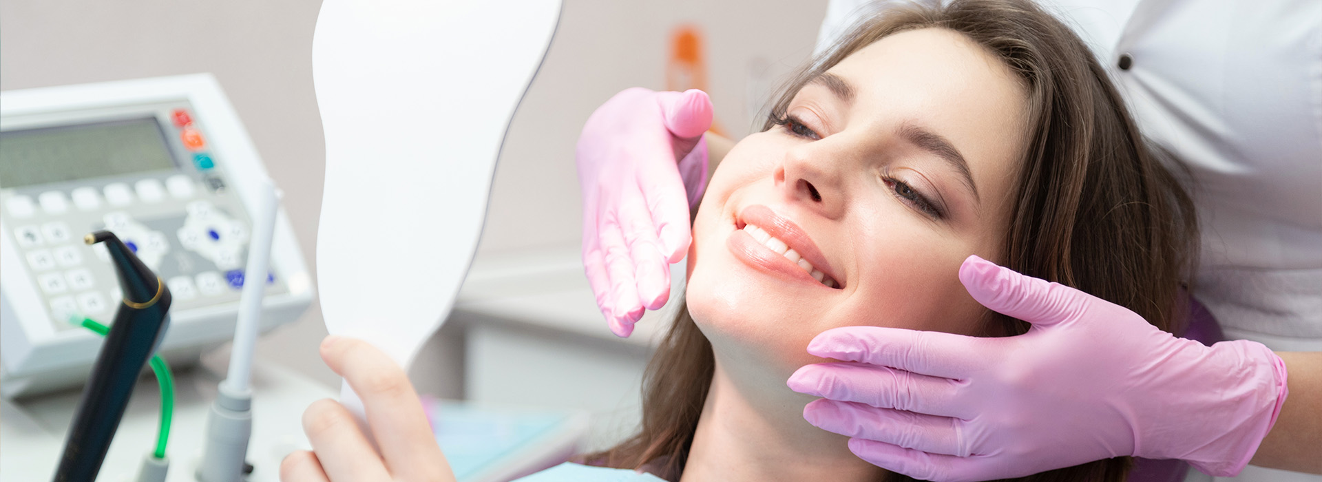 A woman receiving dental care with a dentist performing the procedure.