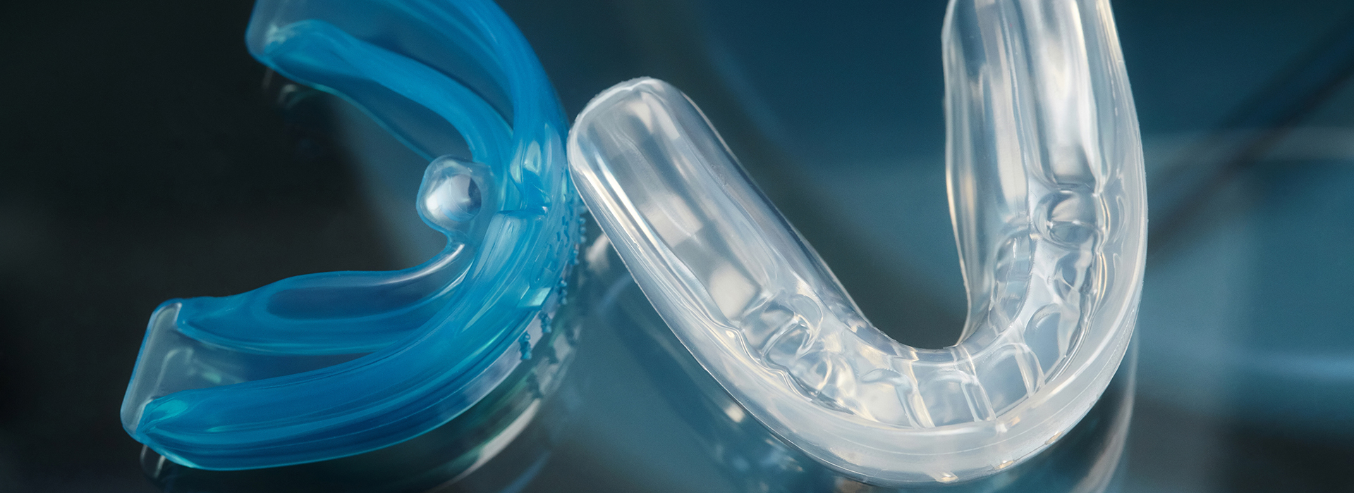 An image of a blue and clear plastic toothbrush with bristles against a blurred background.